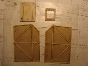 02-15-14: I epoxied the frames to 1/64" ply and trimmed/sanded the
resulting assemblies to precisely the correct (and same) dimensions. 
&nbsp; Here they are pictured after sealing with a carpenter's glue based
sealer.&nbsp; They are pinned down to prevent warping while
drying.<br><br>

Also pictured here are two parts made from 1/8" ply.&nbsp; On the left
is the base of the pod, and on the right is a frame-shaped piece that
covers the diagonal area.&nbsp; It serves as an air in-let and as a
place to run the power and throttle cables.
  